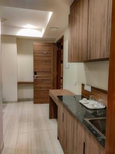 a kitchen with wooden cabinets and a counter top at RR Mount Elite Suites in Chennai