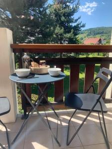 uma mesa com tigelas e cadeiras numa varanda em Le Wizz : appart cosy entre lac et montagne em Saint-Jorioz