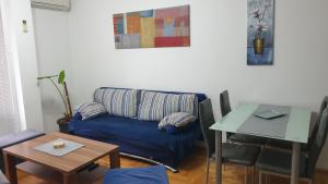 a living room with a blue couch and a table at Apartman MM012 in Požarevac