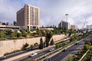 a city with cars driving down a highway with buildings at Ramada Jerusalem Hotel in Jerusalem