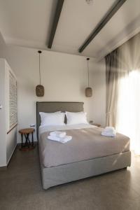 a bedroom with a bed with two towels on it at SKYROS BLUE SUITES in Skiros