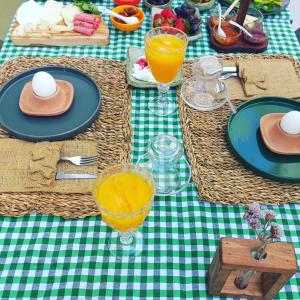 a green and white table with plates and glasses of orange juice at Zarbalı Cunda in Ayvalık +31 photos
