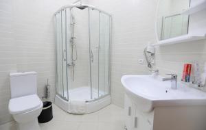 a bathroom with a shower and a toilet and a sink at Khujand Grand Hotel in Khujand