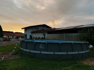 une grande piscine sur l'herbe en face d'une maison dans l'établissement Hartl Hof, à Breitenberg