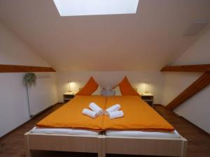 a bedroom with an orange bed with two bows on it at Ferienwohnung 6 in Ochsenhausen