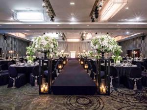a banquet hall with a long table with flowers and candles at Novotel Ambassador Seoul Gangnam in Seoul