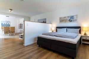 a bedroom with a large bed and a dining room at Deichlamm in Sankt Peter-Ording