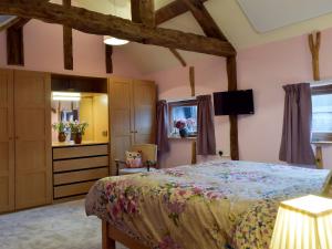 a bedroom with a bed and a tv in a room at Chick Hatch Barn in Kelsale