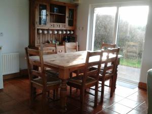 un tavolo in legno con sedie in una cucina con finestra di Betty's Cottage ad Ardea