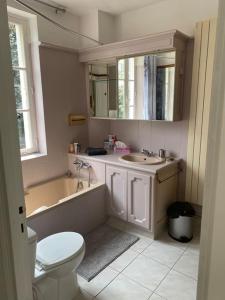 ein Badezimmer mit einer Badewanne, einem WC und einem Waschbecken in der Unterkunft Maison Ancienne à côté des Champs Elysees in Puteaux