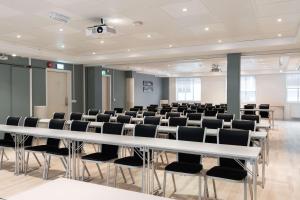 una sala de conferencias con una mesa blanca y sillas en Scandic Bergen City en Bergen