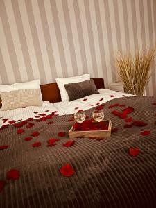 Una cama con pétalos de rosa roja. en Kalinowe Wzgórza, en Charzykowy