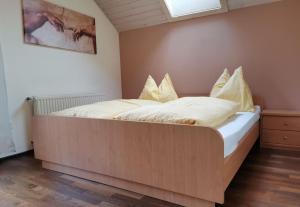 EdlingにあるFerienwohnung Bergblickのベッドルーム1室(白いシーツと黄色い枕の大型ベッド1台付)