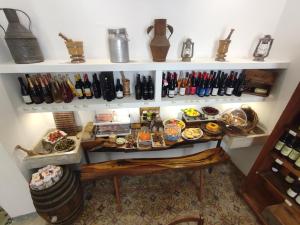 Una habitación con una mesa con comida y botellas de vino en Boutique Rooms and Breakfast GranVeliero, en Trapani