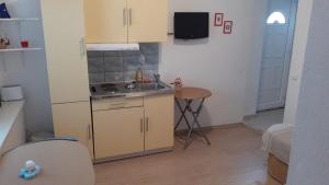 une petite cuisine avec un évier et une table dans l'établissement Apartment Dijana, à Primošten
