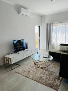 a living room with a tv and a coffee table at Zanaya Apartments in Gaborone