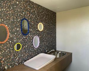 een badkamer met een wastafel en een muur met spiegels bij Camping de Vliert in Bunnik