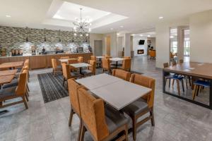 a restaurant with tables and chairs and a bar at La Quinta by Wyndham Bridgeport in Bridgeport