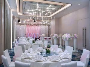 una sala de banquetes con mesas blancas y sillas blancas en Mercure Singapore Bugis en Singapur
