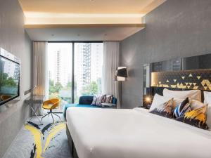 a hotel room with a large bed and a large window at Novotel Singapore On Stevens in Singapore