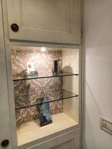 a shelf in a cabinet with a book in it at Suite Latina - San Leonardo in Treviso