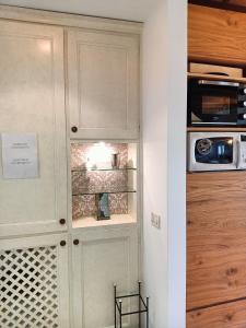 a kitchen with a white cabinet with a microwave at Suite Latina - San Leonardo in Treviso