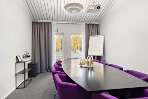 a conference room with purple chairs and a table and a window at Tyleback Hotell; Sure Hotel Collection by Best Western in Halmstad
