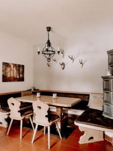 ein Esszimmer mit einem Tisch, Stühlen und einem Kronleuchter in der Unterkunft Gasthof Arriach in Arriach
