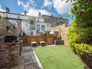 a garden with a lawn in front of a house at Harpers Cottage in Barrowford