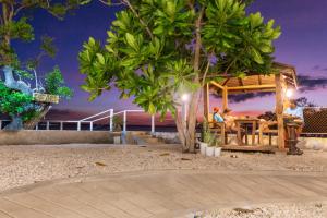 eine Gruppe von Menschen, die in einem Pavillon am Strand sitzen in der Unterkunft Beachfront Mansion and Seascape Villas Calatagan with Outdoor Pool in Calatagan