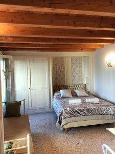 トレヴィーゾにあるスイート ラティーナ サン レオナルドの木製の天井が特徴のベッドルーム1室(ベッド1台付)