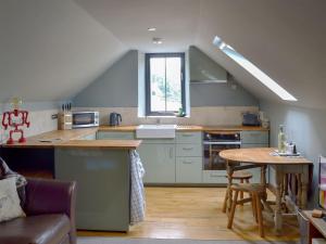 a kitchen with a sink and a table in it at Fishermans Lodge in Highpeak Junction