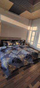 1 dormitorio con 1 cama con sábanas azules y doradas en Pinewood kufri, en Kūfrī