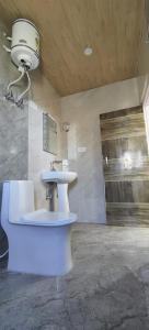 een badkamer met een toilet en een wastafel bij Pinewood kufri in Kūfrī
