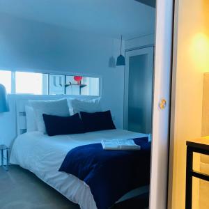 um quarto azul com uma cama grande e almofadas azuis em Rennes Appartement design 50's em Rennes