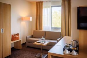 a hotel room with a couch and a table at Lanzcarré Hotel Mannheim, a member of Radisson Individuals in Mannheim