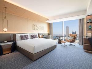 ソウルにあるFairmont Ambassador Seoulのベッド、デスク、椅子が備わるホテルルームです。