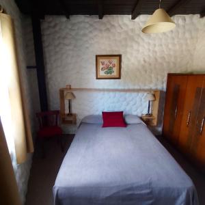 een slaapkamer met een groot bed met een rood kussen bij Exte Maitena in Balneario Claromecó