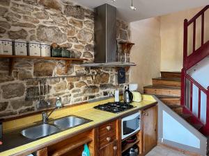 a kitchen with a sink and a stone wall at Le Passage in Concarneau +13 photos