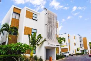 a white building with a tall building at Cap Ouest Luxury Beachfront in Flic-en-Flac