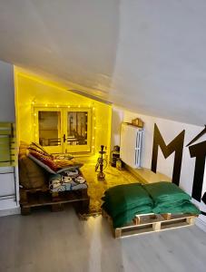 a living room with a bed and a yellow wall at Mansarda 13 in Salerno