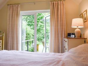 a bedroom with a bed and a sliding glass door at Beck Gate in Alburgh