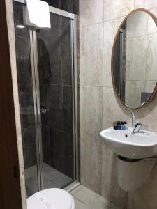 a bathroom with a shower and a sink and a mirror at Grand Silay Hotel in Ankara