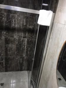 a bathroom with a shower with a black tiled wall at Grand Silay Hotel in Ankara