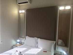 sypialnia z białym łóżkiem i dużym lustrem w obiekcie The Travel Inn Durban w mieście Durban