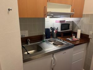 a small kitchen with a sink and a microwave at Hotel 9 små hjem in Copenhagen
