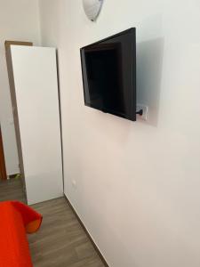 Elle comprend une télévision à écran plat suspendue sur un mur blanc. dans l'établissement B&B l’antico rudere 2, à Cosenza