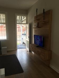 uma sala de estar com uma televisão numa parede de madeira em The Travel Inn Durban em Durban