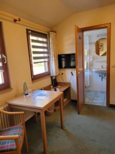 a room with a table and a kitchen with a sink at Hotel Obergfell in Todtnau