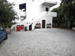 a white building with doors and flowers in front of it at Apartments with sea view1 in Ierapetra